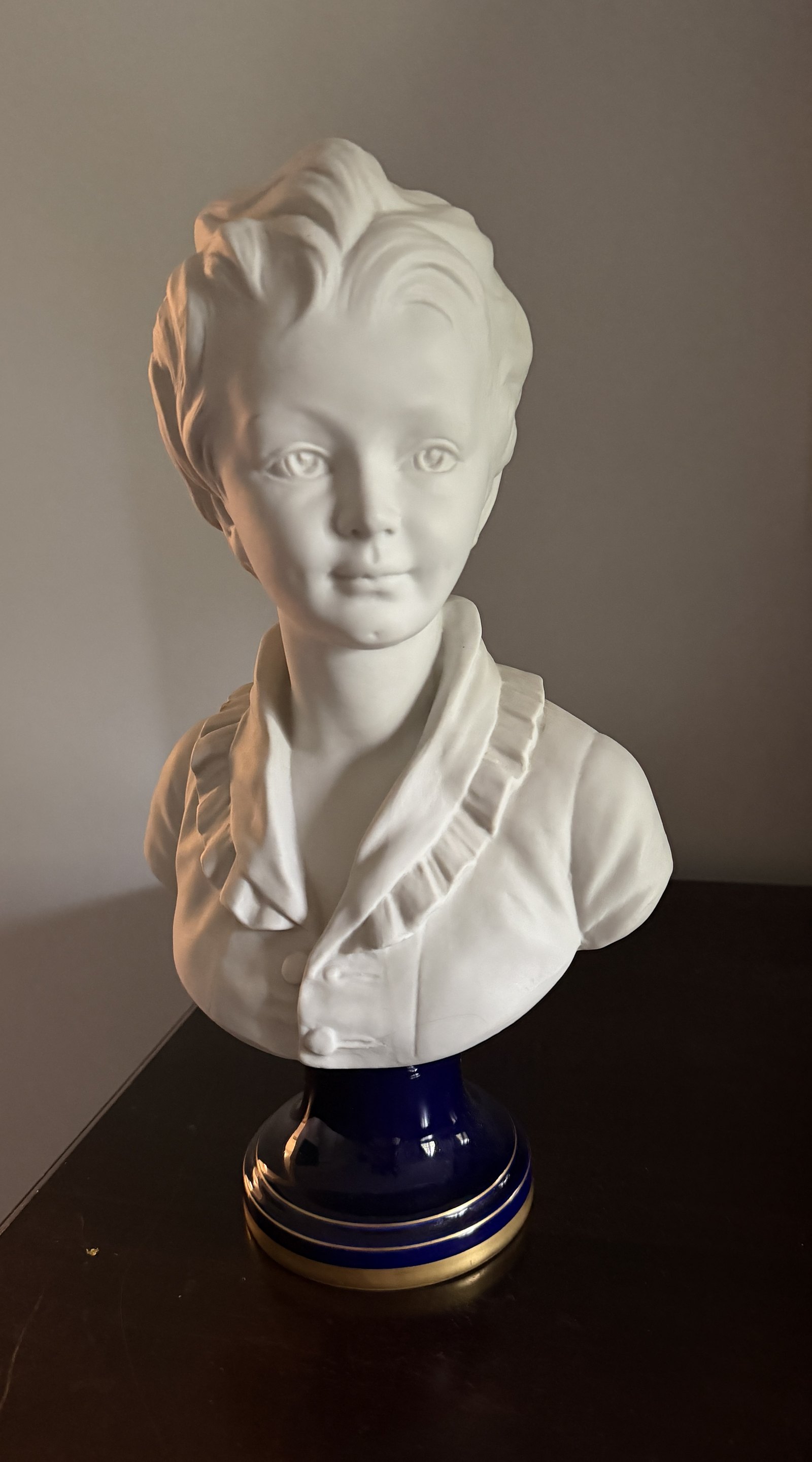 Buste d'enfant en biscuit de porcelaine sur socle bleu cobalt