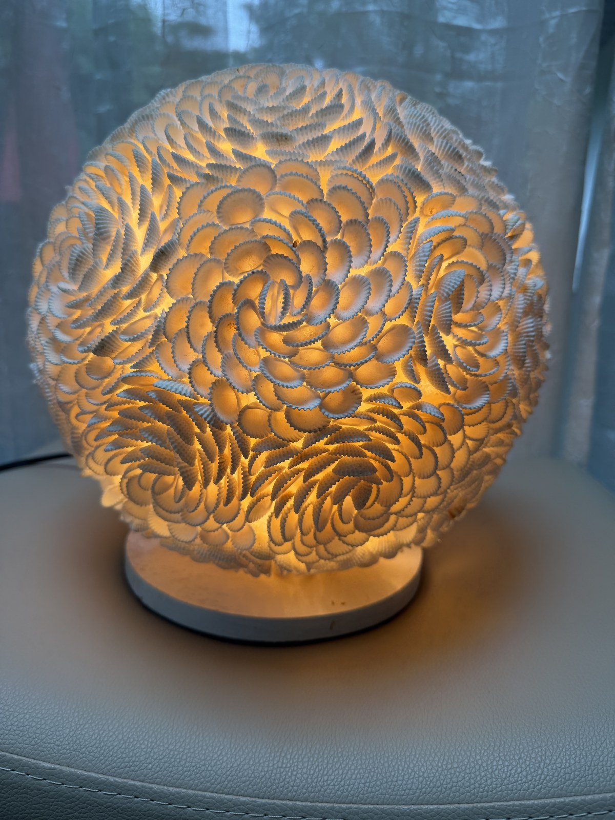 Lampe sphère en coquillages allumée, 27 cm