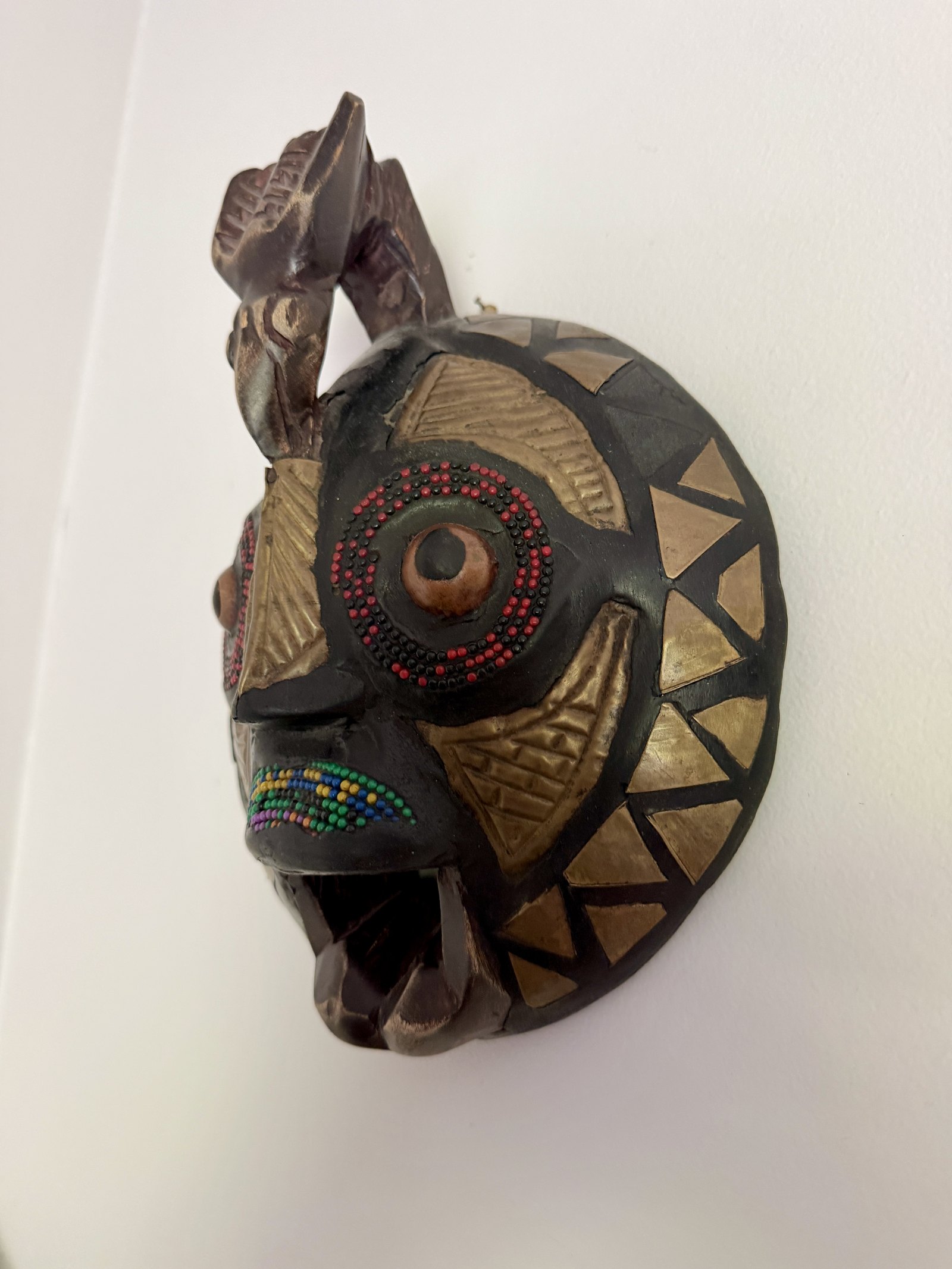 Masque africain mural en bois, chevrons dorés et perles rouges et vertes