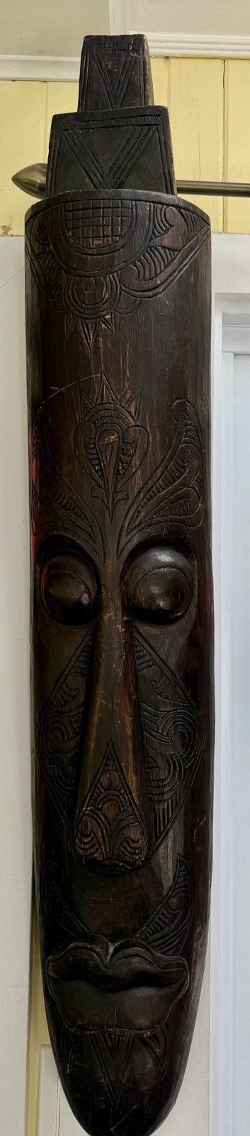 Masque sculpté d'inspiration africaine, long visage tribal en bois sombre