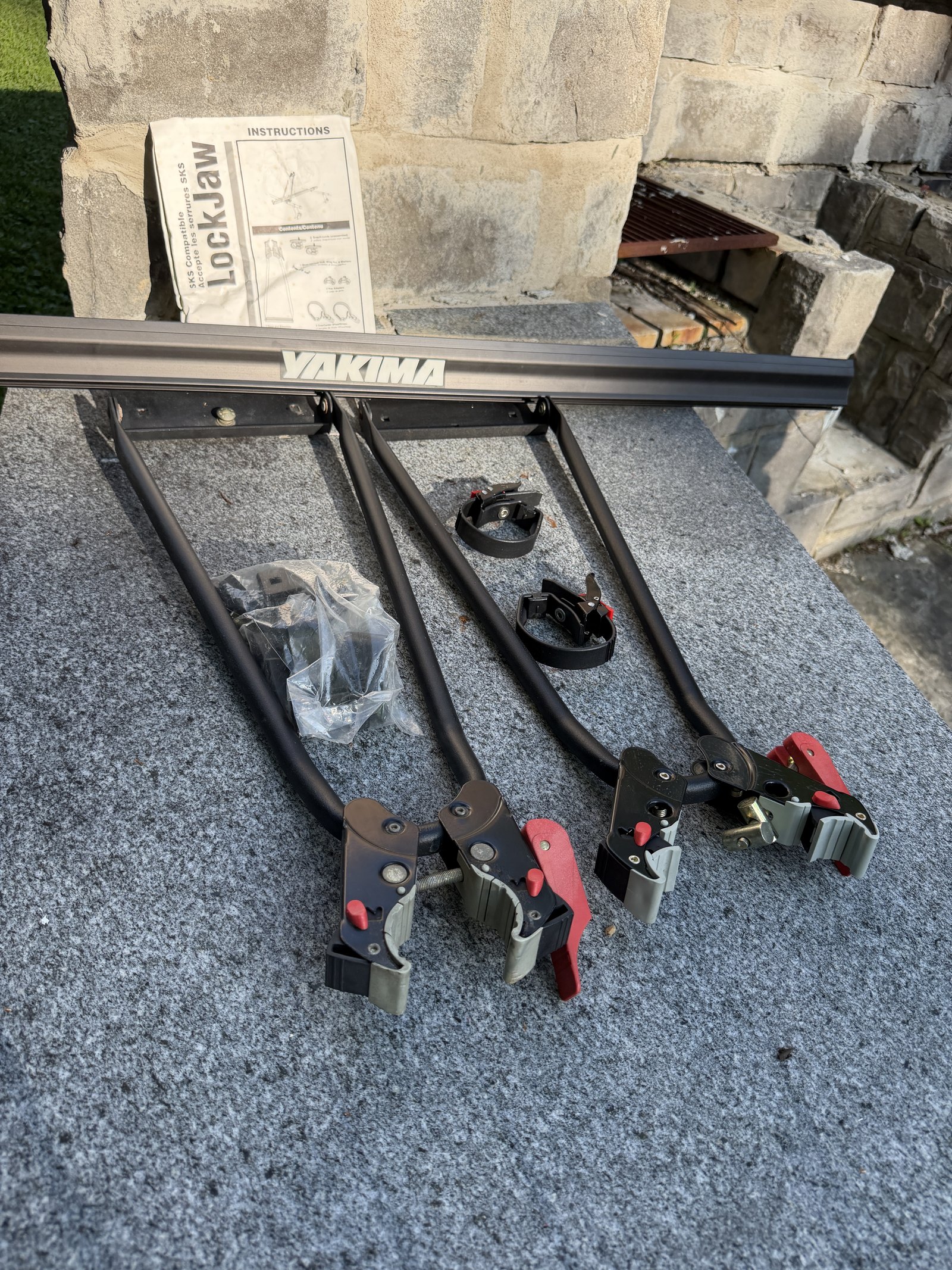 Les deux porte-vélos Yakima LockJaw montés sur leur barre, avec la notice d'origine